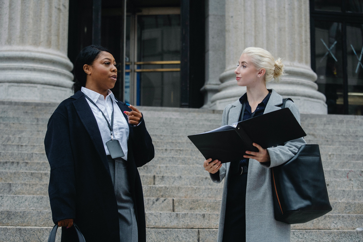 Two professionals outside court.